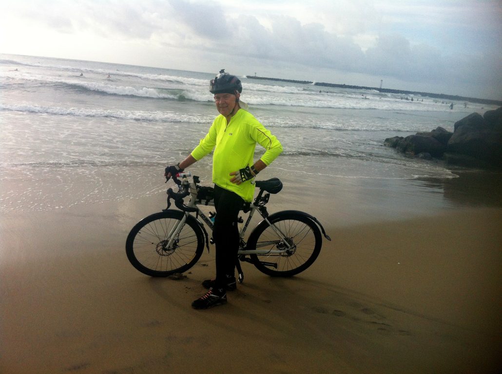 man and touring bike in front of pacific ocean at san diego