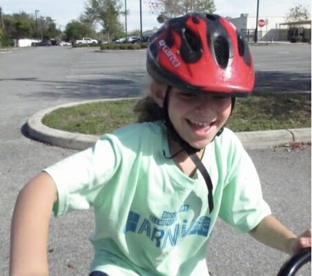 girl on bike with a big smile