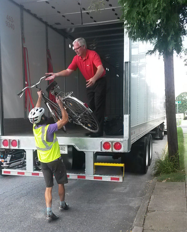 Scott Slingerland hands a bicycle up to Bob Dolan