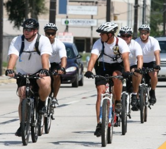 Police officers riding double file.