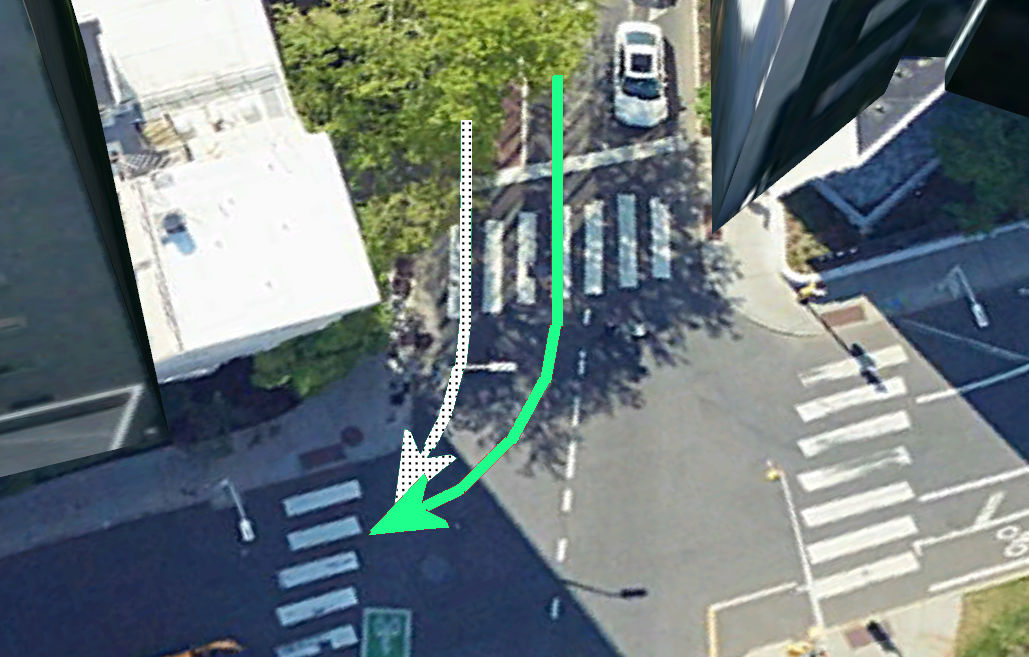 A car turning right on green hooks a bicyclist turning right on a vertical white bar which is is equivalent to turning right on red.