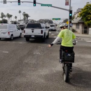 photo of rider bicycling through the challenging interchange using the bike lane as designed and needing to merge with traffic
