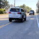 Cyclist's view of a two-way road with a two-way turn lane and narrow should with a crrb, cyclist riding in the right tire track, motorist straddle passing.